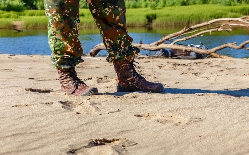 Sodier wear Camouflage tactical boots and stand on the sand road