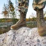 man wears breathable tactical boots on rock