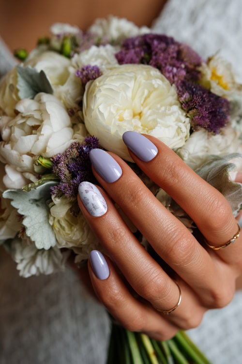 Bride’s hand resting beside wedding bouquet, medium almond nails in soft pastel lavender with a matte finish and white floral stamping 