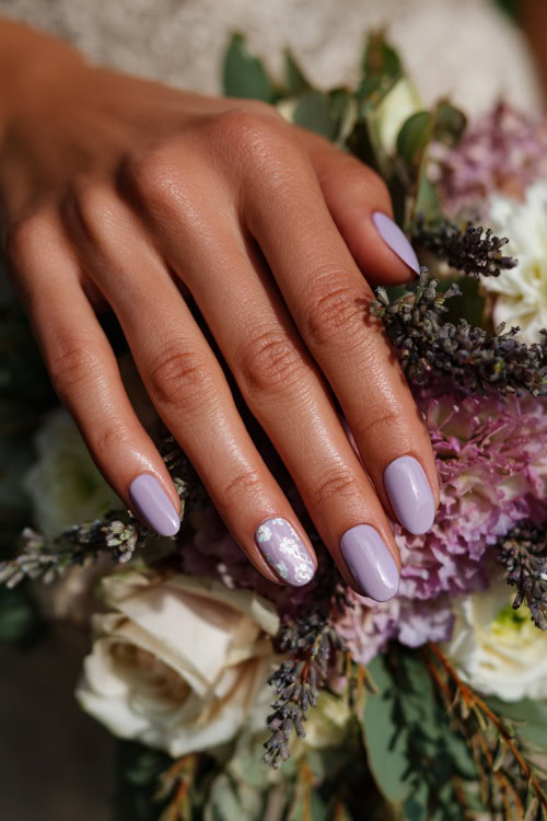 Bride’s hand resting beside wedding bouquet, medium almond nails in soft pastel lavender with a matte finish and white floral stamping 