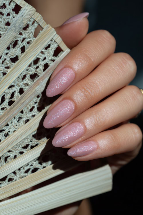 Bridesmaid’s hand holding a lace fan, ballerina-shaped nails in pale mauve with glossy finish and chrome French tips for an elegant, modern look