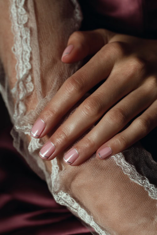 Elegant hand adjusting lace sleeve, square nails in sheer milky pink with fine silver chrome French tips and pearl accents