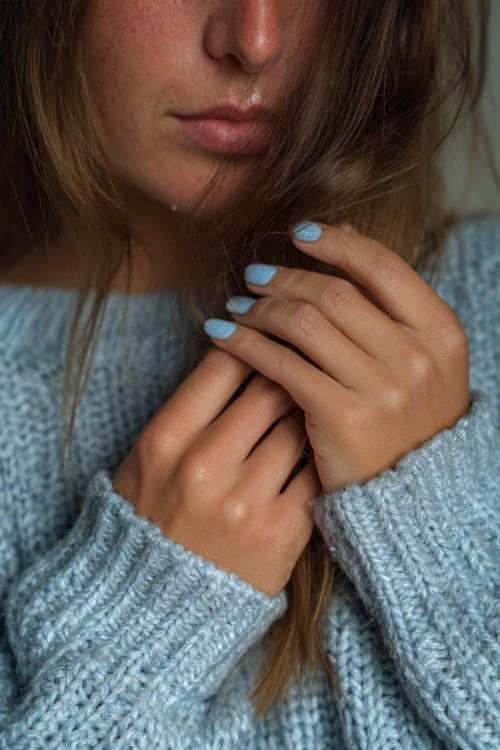 Guest’s fingers brushing through loose hair, pastel blue short square nails with shimmer finish and tiny white heart on each ring finger 