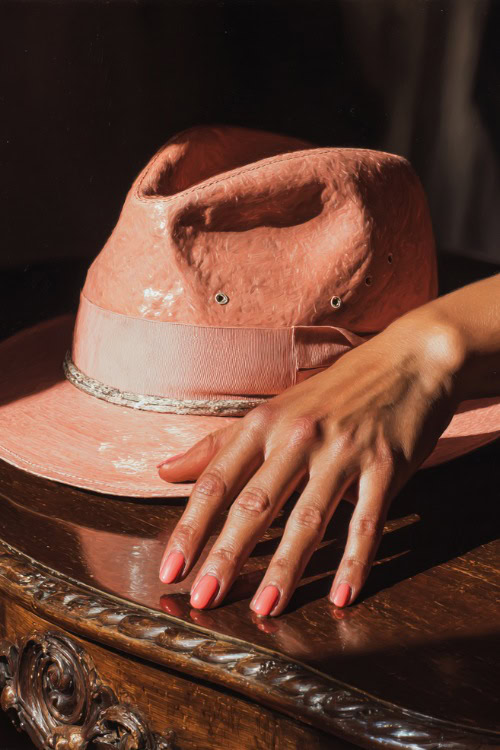 Guest’s hand placing a hat on a table, short ballerina nails in pastel coral with subtle glitter fade and a clear glossy finish
