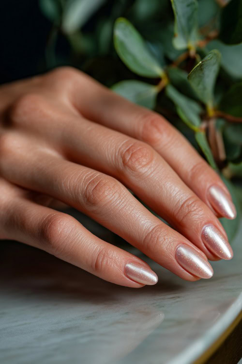 Hand brushing pearls on wedding table, short oval nails in soft peach with satin finish and subtle glitter gradient along the tips 