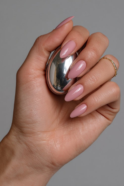 Hand holding a small wedding favor box, almond-shaped nails in pale rose with silver chrome linework along the center 