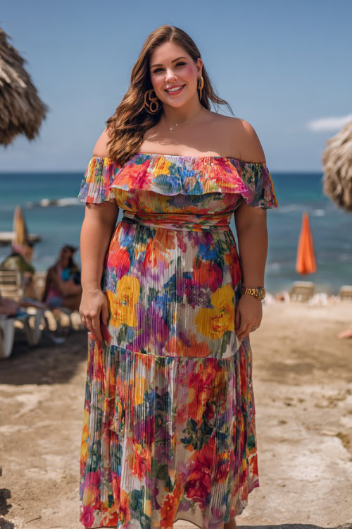 Plus-size woman in a colorful floral off-the-shoulder midi wedding guest dress with tiered skirt and espadrille sandals, posing near a tropical beachside ceremony